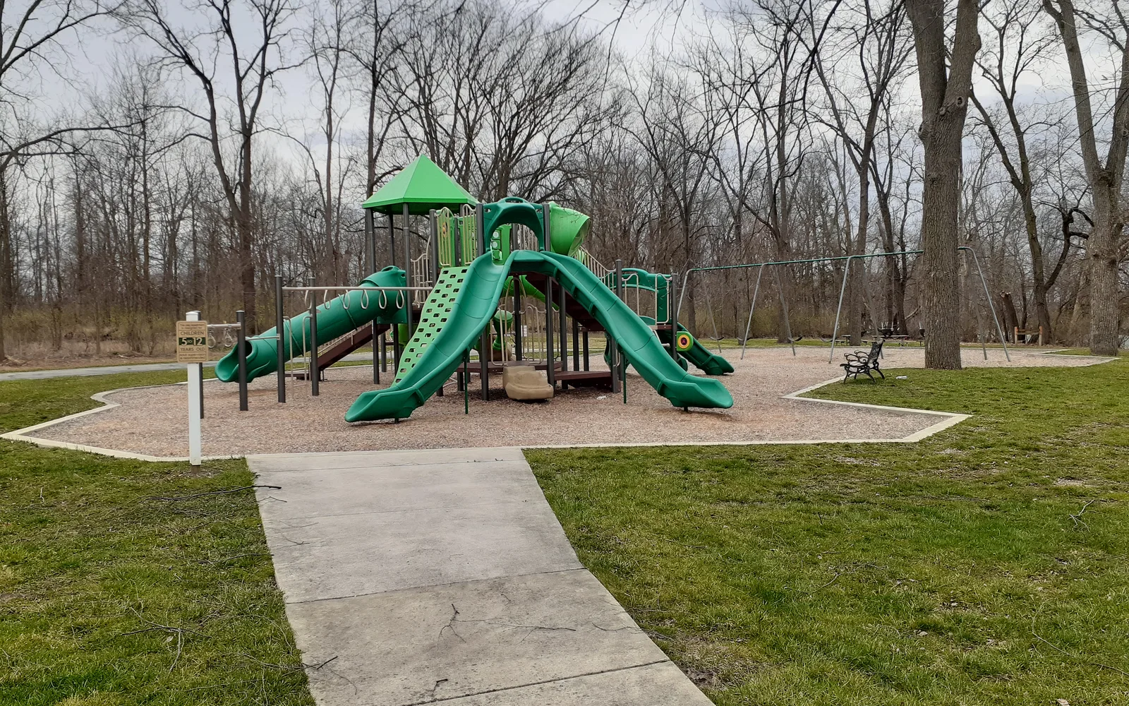 A colorful playground with swings, slides and climbing equipment at a community park